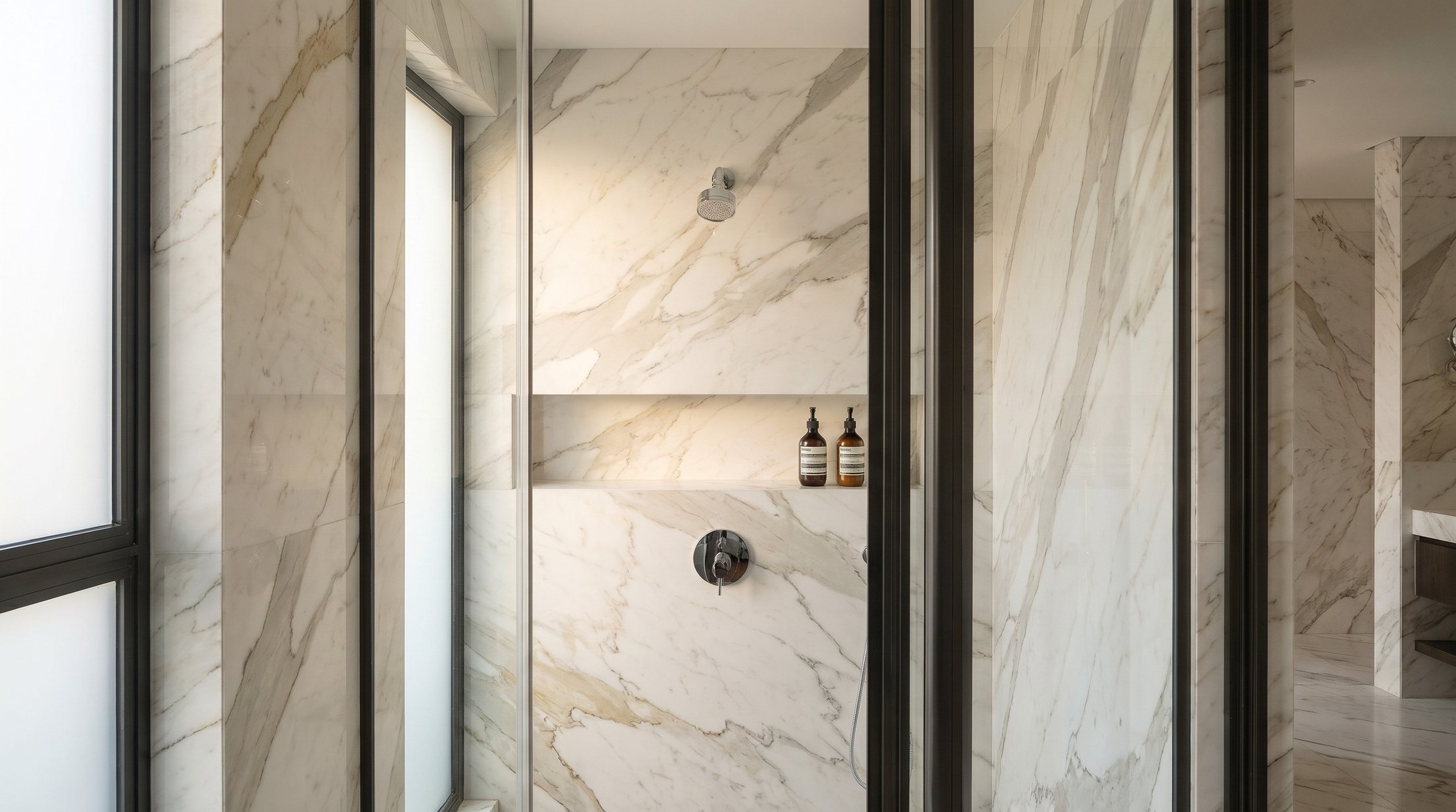 Marble shower wall with a recessed niche